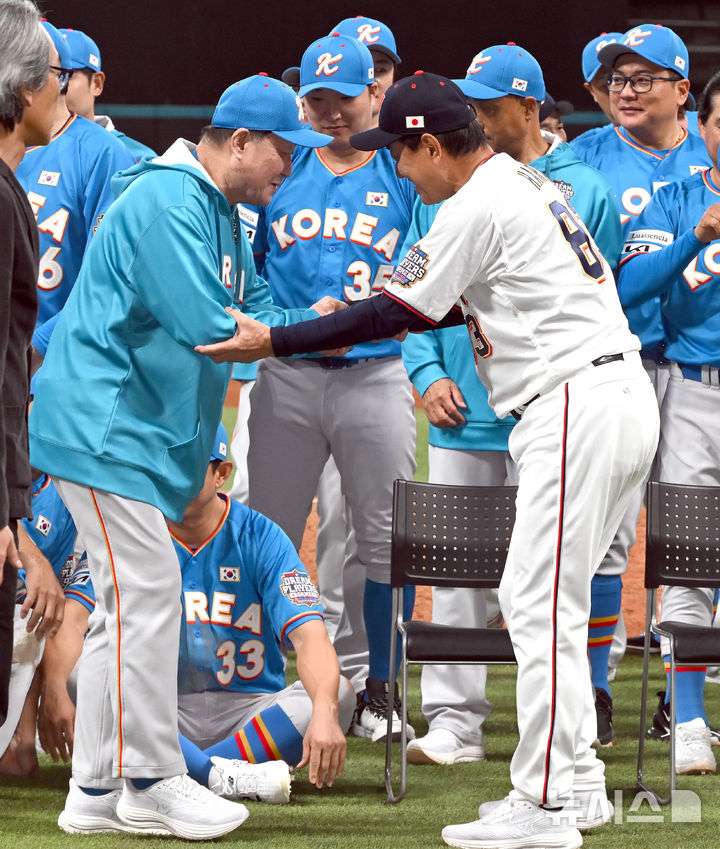 [키타히로시마=뉴시스] 사진공동취재단 = 30일 오후(현지 시간) 일본 홋카이도 키타히로시마시 에스콘필드 홋카이도에서 열린 '한일 드림 플레이어즈 게임'에서 경기를 마친 양팀이 기념촬영을 하기위해 모이자 일본 하라 감독이 한국 김인식 감독을 부축하고 있다. 이 게임은 한국과 일본 프로야구를 대표했던 스타들이 총 출동해 양국의 우정을 이어가는 경기다. 2025.11.30. photo@newsis.com