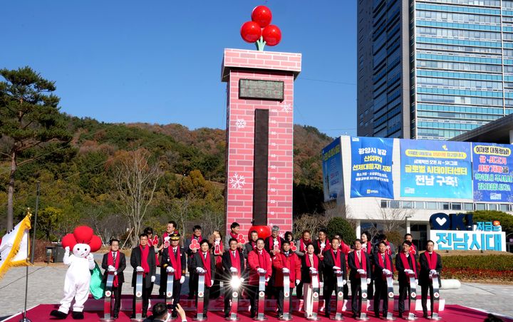 [무안=뉴시스] 김영록 전남지사가 1일 도청 광장 앞 희망 2026 나눔캠페인 출범식 및 사랑의 온도탑 제막식에서 다른 참석자들과 사랑의 온도 올리기 퍼포먼스를 하고 있다. (사진 = 전남도 제공). 2025.12.01. photo@newsis.com *재판매 및 DB 금지
