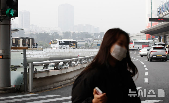 [제주=뉴시스] 우장호 기자 = 미세먼지 농도가 나쁨 수준을 보인 1일 오전 제주국제공항 3층 출발장 앞 도로에서 마스크를 쓴 관광객이 걸어가고 있다. 2025.12.01. woo1223@newsis.com