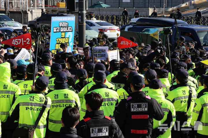[서울=뉴시스] 이영환 기자 = 김유진 12.29 무안공항 제주항공 여객기참사 유가족협의회 대표와 유가족 등이 1일 오후 서울 용산구 대통령실 인근에서 열린 12.29 무안공항 제주항공 여객기참사 유가족협의회·시민사회 긴급 기자회견을 마친 후 이재명 대통령 면담 요청서 제출을 위해 이동하자 경찰이 막아서고 있다. 2025.12.01. 20hwan@newsis.com