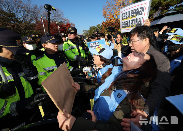 [서울=뉴시스] 이영환 기자 = 김유진 12.29 무안공항 제주항공 여객기참사 유가족협의회 대표와 유가족 등이 1일 오후 서울 용산구 대통령실 인근에서 열린 12.29 무안공항 제주항공 여객기참사 유가족협의회·시민사회 긴급 기자회견을 마친 후 이재명 대통령 면담 요청서 제출을 위해 이동하자 경찰이 막아서고 있다. 2025.12.01. 20hwan@newsis.com