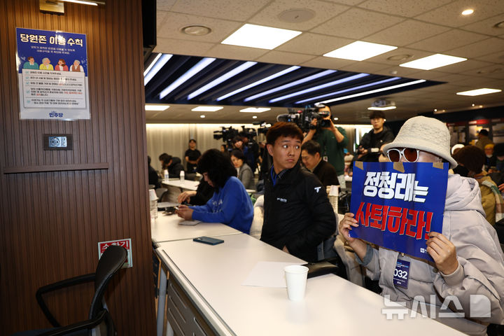 [서울=뉴시스] 김명년 기자 = 1일 오후 서울 여의도 더불어민주당사 당원존에서 열린 '당원 주권 정당 실현을 위한 제도개선 토론회'에서 한 당원이 정청래 대표의 사퇴를 촉구하는 손피켓을 들고 있다. 2025.12.01. kmn@newsis.com