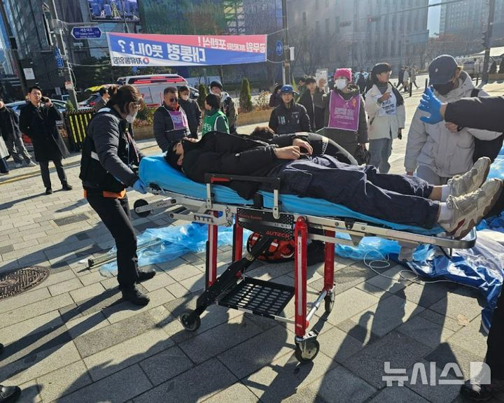 [서울=뉴시스] 전날(1일) 서울 중구 시의회 인근 도시건축전시관 앞 학생인권조례 폐지 반대 농성장이 강제철거된 뒤 부상자가 들것에 실려 이송되고 있다. (사진=아수나로 제공) 2025.12.02. photo@newsis.com