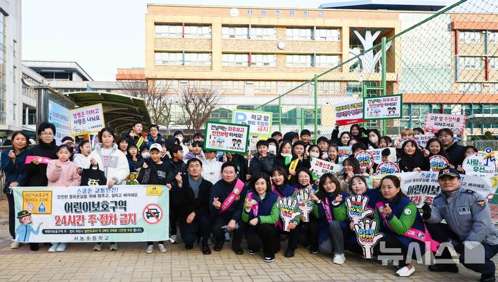 [용인=뉴시스] 경기 용인시 서농초등학교 정문 횡단보도에서 교통지도 봉사활동을 마친 뒤 관계자들과 기념사진 촬영을 하고 있다. (사진=용인시 제공) 2025.11.02. photo@newsis.com