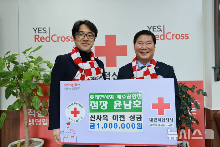 [제주=뉴시스] 윤남호(왼쪽) 롯데면세점 제주공항점 점장이 2일 대한적십자사 제주지사에 100만원을 기부한 후 기념촬영하고 있다. (사진=대한적십자사 제주지사 제공) 2025.12.02. photo@newsis.com *재판매 및 DB 금지