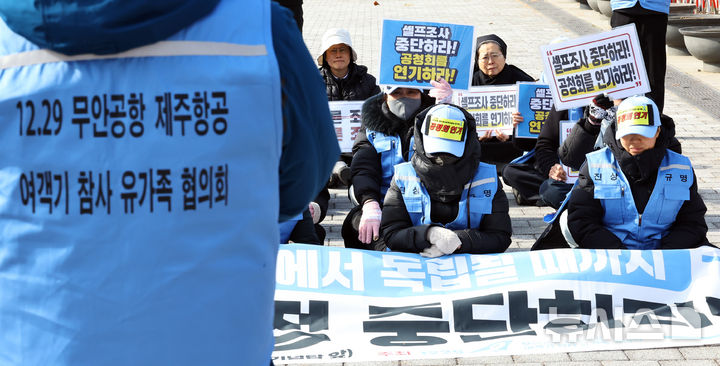 [서울=뉴시스] 최진석 기자 = 12.29 무안공항 제주항공 여객기참사 유가족협의회 유가족들이 2일 서울 용산 대통령실 인근에서 사고조사 공청회 연기 촉구 피켓을 들고 있다. 2025.12.02. myjs@newsis.com