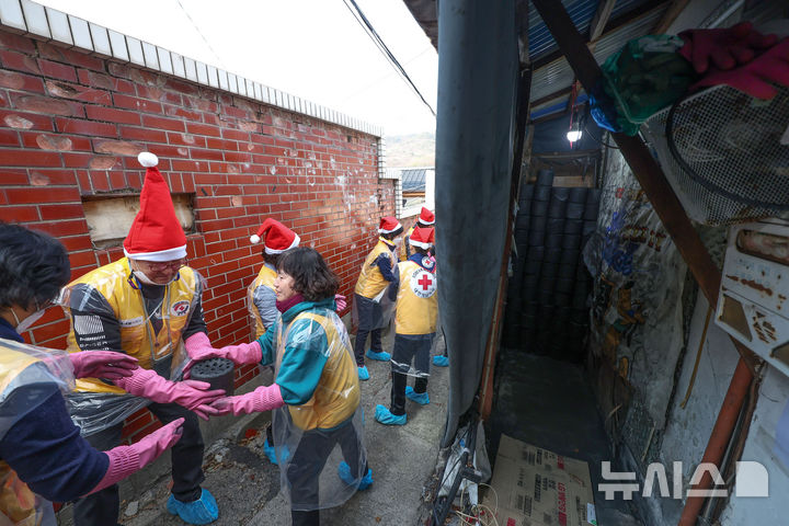 [서울=뉴시스] 김선웅 기자 = 적십자 봉사원·고려아연 임직원들이 2일 서울 노원구 상계동에서 연탄 나눔 봉사활동을 하고 있다. 2025.12.02. mangusta@newsis.com