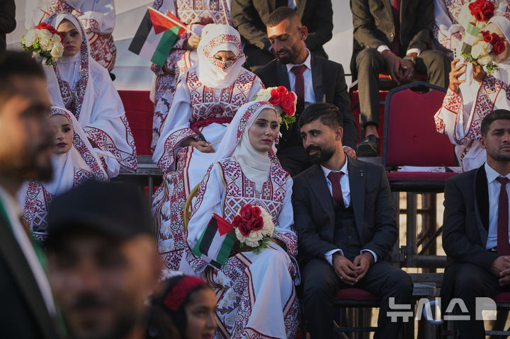 [칸 유니스=AP/뉴시스] 2일(현지 시간) 팔레스타인 가자지구 남부 칸 유니스에서 팔레스타인인들이 합동결혼식에 참석해 있다. 2025.12.03.