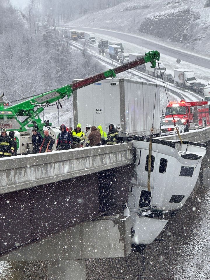 [사우스사이드( 미 웨스트버지니아주)=AP/뉴시스] 미 동부 폭설로 추수감사절 직후 교통난이 증가한 가운데 12월 2일(현지시간) 웨스트버지니아주 35번 고속도로에서 추락해 다리위에 매달린 트레일러 트럭 앞 부분을 구조대가 견인하고 있다. 2025.12.03. 