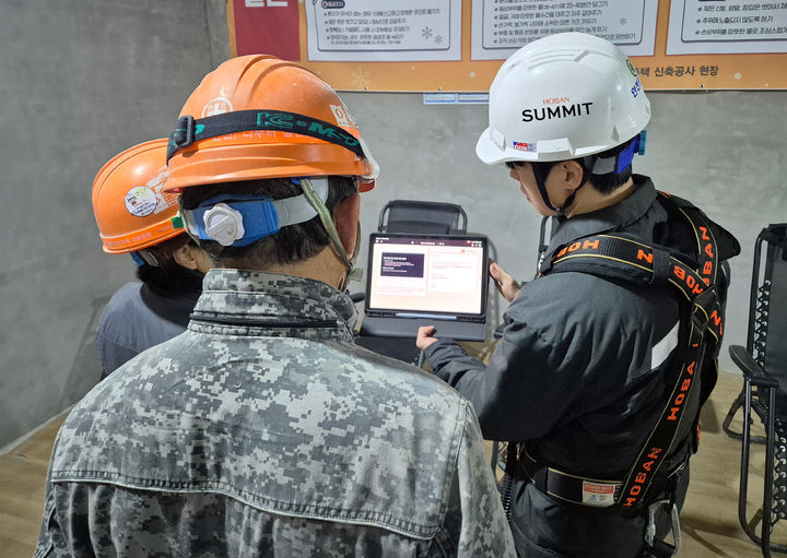 [서울=뉴시스] 호반건설 직원이 건설 현장에서 AI 동시번역 플랫폼 ‘호반커넥트’를 활용해 근로자들과 대화하고 있다. (사진=호반 제공) 2025.12.03. photo@newsis.com *재판매 및 DB 금지