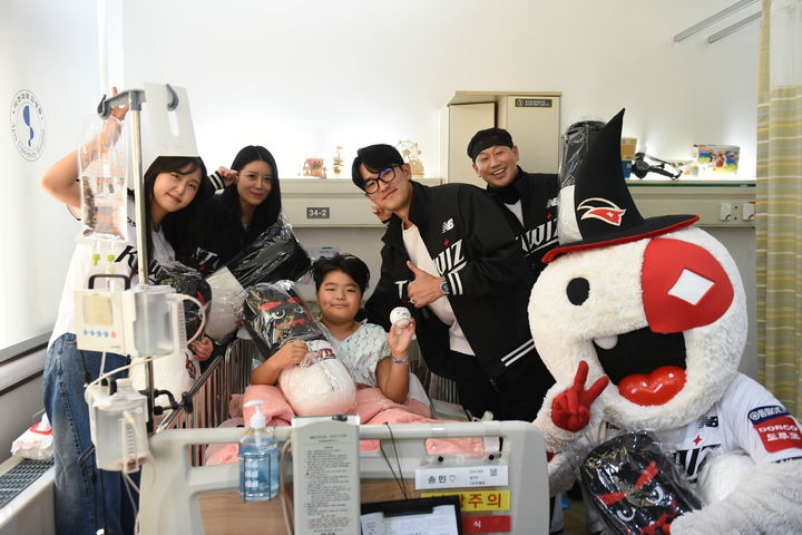 [수원=뉴시스] 2일 아주대병원 본관 6층 소아병동에서 한국프로야구 KT wiz 고영표와 응원단이 입원 중인 환아와 함께 기념사진을 촬영하고 있다. (사진=아주대의료원 제공) 2025.12.03. photo@newsis.com *재판매 및 DB 금지