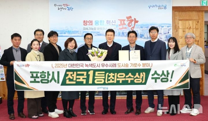 [포항=뉴시스] 송종욱 기자 = 포항시가 산림청의 '2025년 녹색 도시 우수 사례 공모'에 도시 숲 분야 최우수상을 받은 후 3일 시청 대외협력실에서 이강덕 시장과 시 그린웨이추진과 직원이 기념 촬영하고 있다. (사진=포항시 제공) 2025.12.03. photo@newsis.com