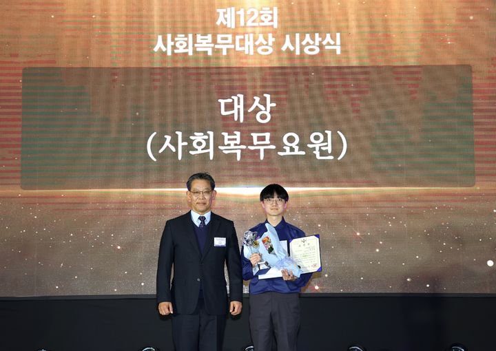 [서울=뉴시스] 김용무 병무청 차장이 3일 정부세종컨벤션센터에서 개최된 제12회 사회복무대상(大賞) 시상식에서 대상 수상자인 박준영씨에게 표창장을 수여한 후 기념촬영을 하고 있다. (사진=병무청 제공) 2025.12.03. photo@newsis.com *재판매 및 DB 금지