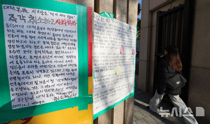 [서울=뉴시스] 홍효식 기자 = 동덕여자대학교 공학 전환 타당성에 대한 외부 용역 결과 발표와 '공학 전환에 대한 8000 동덕인 의견 조사' 학생 총투표가 실시되는 3일 서울 성북구 동덕여대 정문에 래커칠 제거 행사 철회 관련 대자보가 부착되어 있다. 2025.12.03. yesphoto@newsis.com