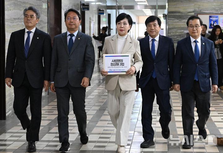 [서울=뉴시스] 김명년 기자 = 전현희 더불어민주당 사법불신 극복·사법행정 정상화 TF 위원장과 의원들이 3일 오후 서울 여의도 국회 의안과에서 사법행정 정상화 3법을 제출하기 위해 이동하고 있다.(공동취재) 2025.12.03. photo@newsis.com