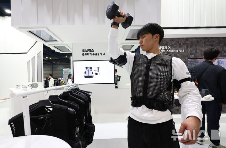 [서울=뉴시스] 김선웅 기자 = 3일 서울 강남구 코엑스에서 열린 2025 코리아 테크 페스티벌 현대차그룹 부스에서 관계자가 로보틱스랩의 산업용 웨어러블 로봇 '엑스블 숄더'를 시연하고 있다. 2025.12.03. mangusta@newsis.com