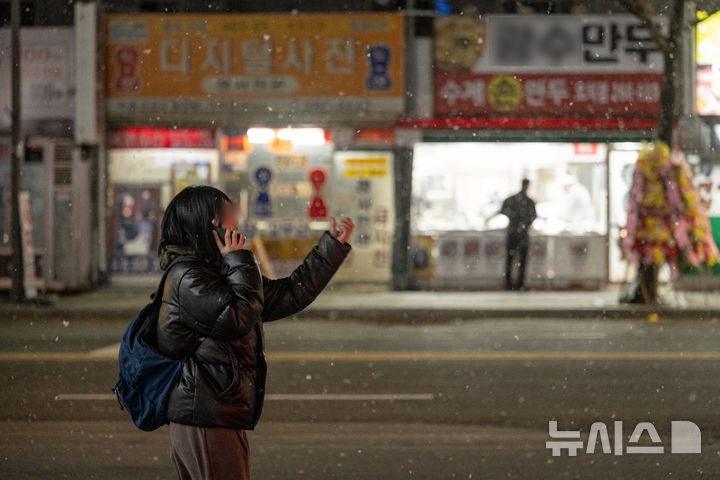 [광주=뉴시스] 이영주 기자 = 광주지역에 눈이 내리는 3일 오후 광주 북구 오치동 한 거리에서 시민이 눈을 맞으며 길을 걷고 있다. 2025.12.03. leeyj2578@newsis.com