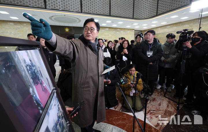 [서울=뉴시스] 국회사진기자단 = 우원식 국회의장이 3일 서울 여의도 국회에서 열린 '비상계엄 해제 1주년 기억행사' 다크투어에서 도슨트로 참여해 시민들과 함께 계엄군이 들이닥쳤던 3층 중앙홀을 돌아보고 있다. 2025.12.03. photo@newsis.com