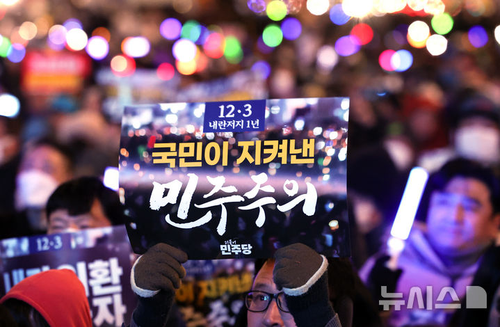 [서울=뉴시스] 황준선 기자 = 12·3 비상계엄 사태 1년을 맞은 3일 밤 서울 여의도 국회 앞에서 열린 12.3 내란외환 청산과 종식, 사회대개혁 시민대행진에서 참가자들이 피켓을 득고 있다. 2025.12.03. hwang@newsis.com