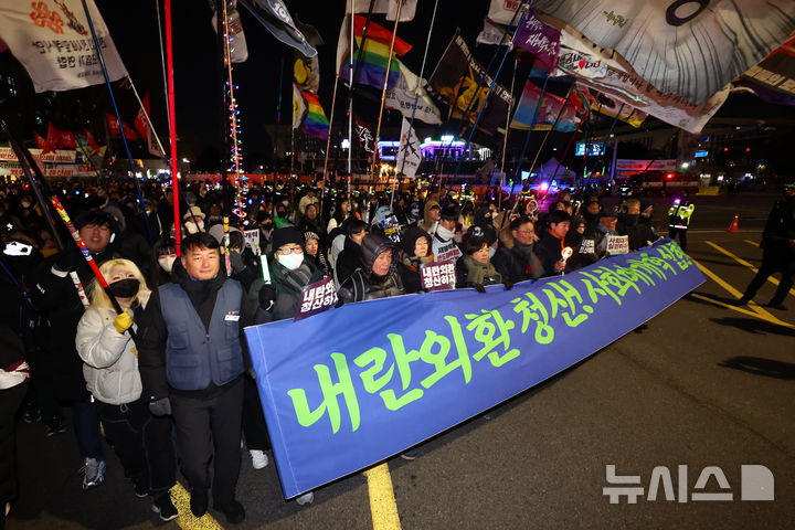 [서울=뉴시스] 황준선 기자 = 12·3 비상계엄 사태 1년을 맞은 3일 밤 서울 여의도 국회 앞에서 열린 12.3 내란외환 청산과 종식, 사회대개혁 시민대행진에서 참석자들이 국민의힘 당사를 향해 행진하고 있다. 2025.12.03. hwang@newsis.com
