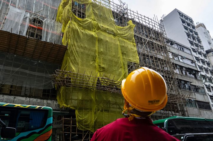 [홍콩=AP/뉴시스] 홍콩에서 군대식 훈련을 하던 시민들이 잇따라 ‘정부 전복혐의’ 등으로 체포되고 일부는 기소됐다고 홍콩 사우스차이나모닝포스트(SCMP)가 14일 보도했다. 사진은 지난 4일 홍콩 몽콕 지역의 한 건물 보수 공사 현장에서 노동자들이 그물망을 제거하는 모습. 2025.12.15. 
