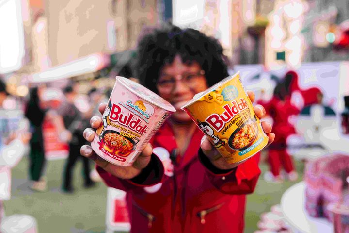 [서울=뉴시스] 외국인이 불닭볶음면 제품을 들고 있는 모습.(사진=삼양식품 제공) *재판매 및 DB 금지
