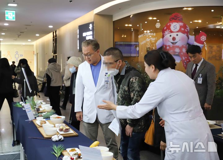 [부천=뉴시스]정일형 기자 = 문종호 순천향대 부천병원장(좌측)이 환자와 함께 ‘2025년 암 환자 식단 전시회’를 관람하고 있다. (사진=순천향대 부천병원 제공)
