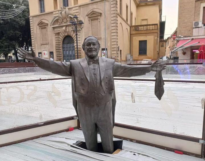 [뉴시스] 이탈리아 동부 페사로시 중앙 광장에 야외 아이스링크를 설치하는 과정에서 세계 3대 테너 루치아노 파바로티의 동상이 공사용 구조물에 가려져 유족이 '고인 모독'이라며 반발했다. (사진 = 가디언 캡처) 2025.12.04. *재판매 및 DB 금지