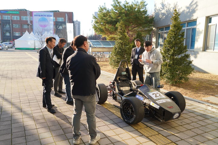 [아산=뉴시스] 선문대학교 미래자동차공학부 학생들이 2025 충남 RISE 공유대학 캡스톤디자인 경진대회 심사위원들에게 출품작을 설명하고 있다. (사진=선문대 제공) 2025.12.04 photo@newsis.com *재판매 및 DB 금지