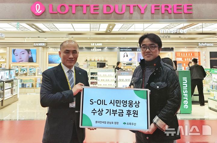 [제주=뉴시스] 윤남호(오른쪽) 롯데면세점 제주공항점장이 초록우산 제주지역본부에 후원금 100만원을 전달한 후 기념촬영하고 있다. (사진=초록우산 제주지역본부 제공) 2025.12.04. photo@newsis.com *재판매 및 DB 금지