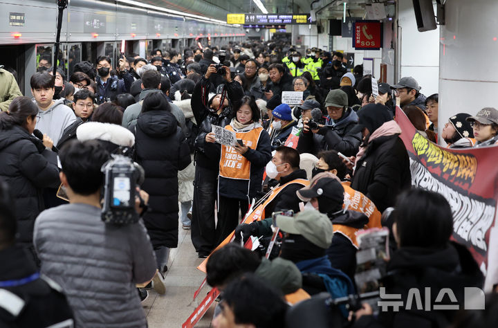 [서울=뉴시스] 이영환 기자 = 4일 오전 서울 종로구 지하철5호선 광화문역에서 '제67차 출근길 지하철 탑니다’ 시위가 진행중인 가운데 출근길 시민들이 이동하고 있다. 2025.12.04. 20hwan@newsis.com