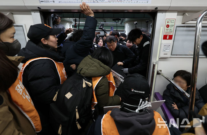 [서울=뉴시스] 이영환 기자 = 전국장애인차별철폐연대(전장연) 회원들이 4일 오전 서울 종로구 지하철5호선 광화문역에서 열린 '제67차 출근길 지하철 탑니다’ 시위에 참석하기 위해 5호선에 탑승해 광화문역에 도착해 안전발판 교체를 요구하고 있다. 2025.12.04. 20hwan@newsis.com
