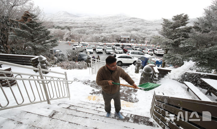 [제주=뉴시스] 우장호 기자 = 기습 추위가 절정에 달한 4일 오전 제주 한라산 1100고지 휴게소에서 관계자가 계단에 쌓인 눈을 치우느라 구슬땀을 흘리고 있다. 2025.12.04. woo1223@newsis.com
