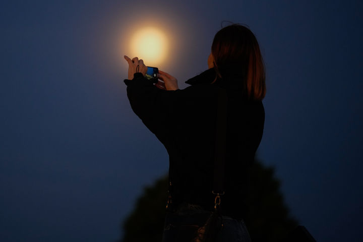 [이스탄불=AP/뉴시스] 4일(현지 시간) 튀르키예 이스탄불에서 한 여성이 올해 마지막 보름달인 슈퍼문을 휴대전화에 담고 있다. 2025.12.05.