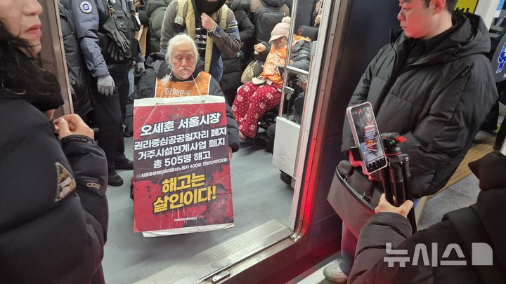 [서울=뉴시스] 전상우 수습기자 = 박경석 전국장애인차별철폐연대(전장연) 상임공동대표가 5일 오전 서울 지하철 4호선 혜화역 열차 안에서 장애등급제 폐지와 권리중심일자리 최중증장애인노동자 해고 철회를 촉구하며 선전전을 벌이고 있다. 2025.12.05. swoo@newsis.com