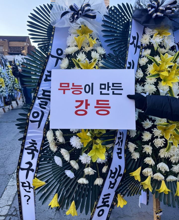 [대구=뉴시스] 정재익 기자 = 5일 오전 대구 중구 대구시청 동인청사 주차장에 대구 프로축구단 대구FC의 정상화를 요구하는 취지의 근조화환이 설치되고 있다. 대구FC가 10년 만에 강등된 가운데 팬 서포터즈 연대 '그라지예'는 축구단을 둘러싼 각종 논란에 대한 쇄신을 요구하는 근조화환 시위를 벌였다. 2025.12.05. *재판매 및 DB 금지