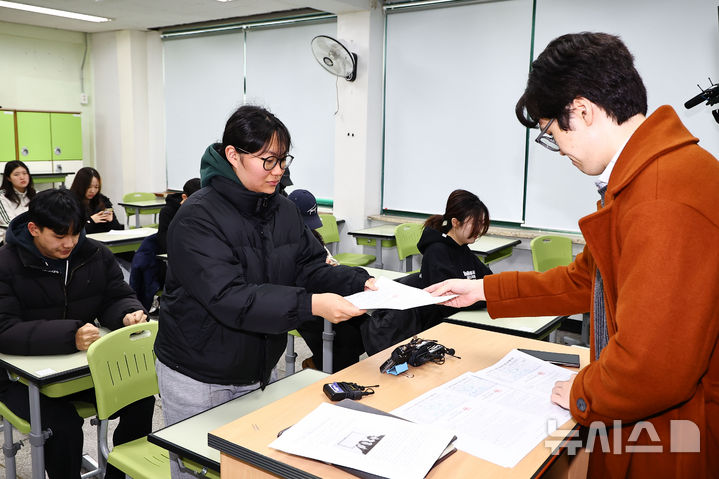 [서울=뉴시스] 홍효식 기자 = 2026학년도 대학수학능력시험(수능) 성적표가 배부된 5일 서울 광진구 광남고등학교에서 담임선생님이 수험생에게 성적표를 배부하고 있다. (공동취재) 2025.12.05. photo@newsis.com