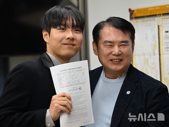 [광주=뉴시스] 5일 오전 광주 서구 서석고등학교에서 2026학년 대학수학능력시험에서 만점을 기록한 최장우 학생이 이정선 광주시교육청 교육감과 기념촬영을 하고 있다. 2025.12.05. lhh@newsis.com