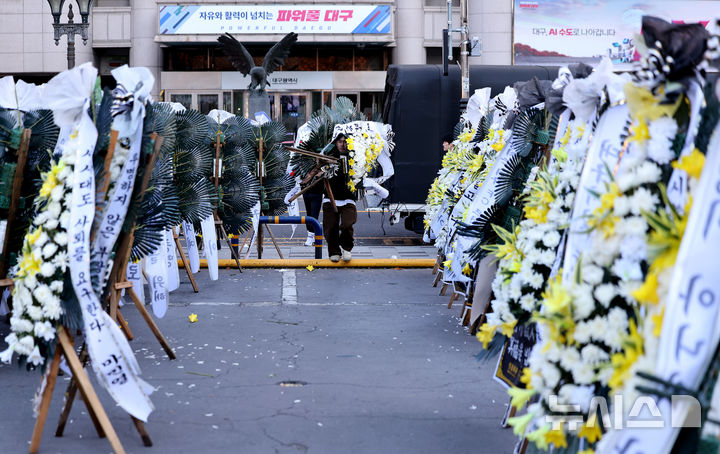 [대구=뉴시스] 이무열 기자 = 5일 대구 중구 대구시청 동인청사 주차장에 대구 프로축구단 대구FC의 정상화를 요구하는 취지의 근조화환이 놓여져 있다. 대구FC가 10년 만에 강등된 가운데 팬 서포터즈 연대 ‘그라지예’는 축구단을 둘러싼 각종 논란에 대한 쇄신을 요구하는 근조화환 시위를 벌이고 있다. 2025.12.05. lmy@newsis.com