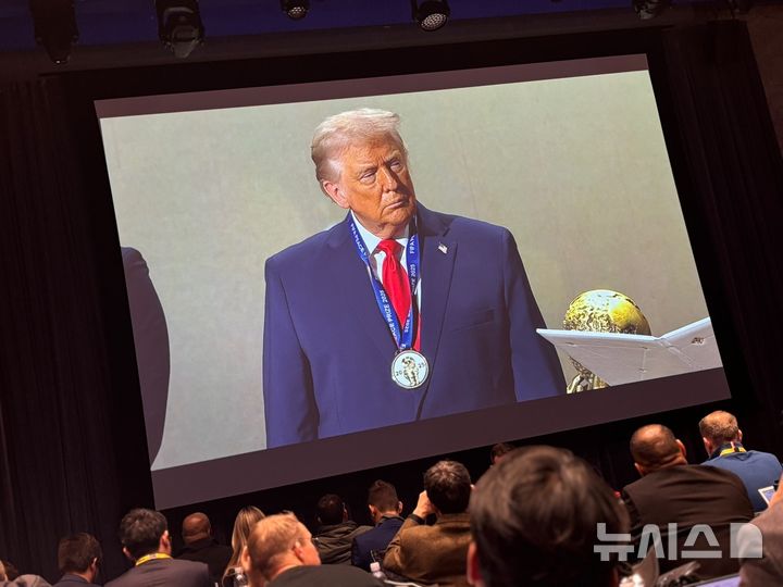 [워싱턴=뉴시스]이윤희 특파원 = 잔니 인판티노 국제축구연맹(FIFA) 회장이 5일(현지 시간) 미국 워싱턴DC 케네디센터에서 개최된 북중미월드컵 조 추첨식에서 트럼프 대통령에게 1회 FIFA 평화상을 수여했다. 케네디센터에 마련된 프레스센터에 마련된 중계화면에 트럼프 대통령이 메달을 건 모습이 나오고 있다. 2025.12.06.