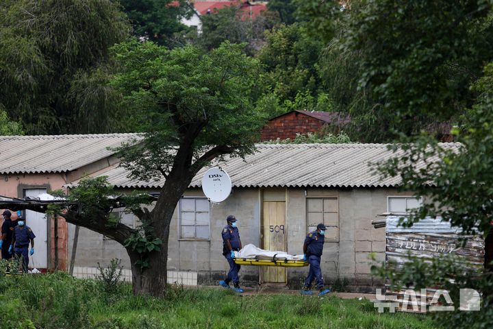[AP/뉴시스] 지난 6일 남아공 프레토리아 인근 주점에서 다수에 의한 다수 살해 총격 사건이 발생한 뒤 경찰이 시신을 옮기고 있다. 당시 12명이 사망했다.