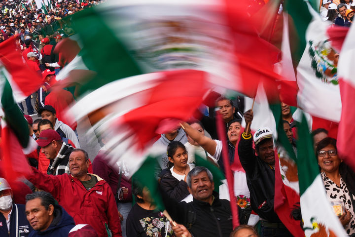 [멕시코시티= AP/ 뉴시스] 멕시코시티에 모인 클라우디아 세인바움 대통령의 지지자들이 여당의 집권 7주년을 기념하는 군중대회에서 국기를 흔들며 축하하고 있다.  이 날 미초아칸 주에서는 주지사가 이 행사에 참석하는 동안 6일 코아후아야나 시 경찰서에서 폭발물이 터져 9명의 사상자가 발생했다. 2025. 12. 07.