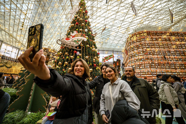 [서울=뉴시스] 정병혁 기자 = 7일 서울 강남구 코엑스를 찾은 시민과 여행객들이 크리스마스 트리 앞에서 사진을 찍으며 즐거운 시간을 보내고 있다. 2025.12.07. jhope@newsis.com