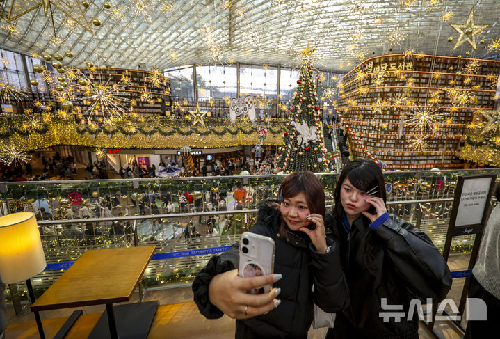 [서울=뉴시스] 정병혁 기자 = 7일 서울 강남구 코엑스를 찾은 시민과 여행객들이 크리스마스 트리 앞에서 사진을 찍으며 즐거운 시간을 보내고 있다. 2025.12.07. jhope@newsis.com