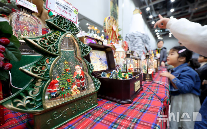 [대구=뉴시스] 이무열 기자 = 7일 대구 북구 엑스코에서 열린 ‘2025 대구 크리스마스 페어’를 찾은 한 어린이가 크리스마스 장식 소품을 살펴보고 있다. 2025.12.07. lmy@newsis.com