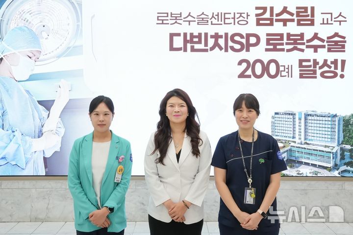 [인천=뉴시스] 김수림 국제성모병원 로봇수술센터장(가운데)이 다빈치SP 로봇수술 200례를 달성해 기념 촬영하고 있다. (사진=국제성모병원 제공) 2025.12.08. photo@newsis.com