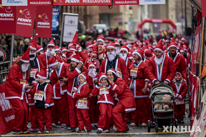 [부다페스트=신화/뉴시스] 7일(현지 시간) 헝가리 부다페스트에서 열린 연례 산타 달리기 대회에 참가한 산타클로스 복장의 참가자들이 출발을 기다리고 있다. 이날 행사에는 약 4,500명이 산타 복장으로 함께해 도심을 붉게 물들였다. 2025.12.08.
