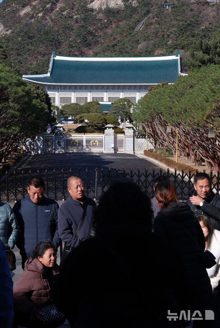 [서울=뉴시스] 이영환 기자 = 대통령실이 용산 대통령 집무실을 청와대로 이전하는 작업을 본격적으로 시작한 8일 오후 서울 종로구 청와대 앞에서 관광객들이 기념촬영을 하고 있다.2022년 5월 윤석열 정부 출범과 함께 시작된 '용산 시대'가 3년 7개월 만에 막을 내리는 것으로 성탄절께 업무시설 이전을 마무리할 계획이다. 2025.12.08. 20hwan@newsis.com