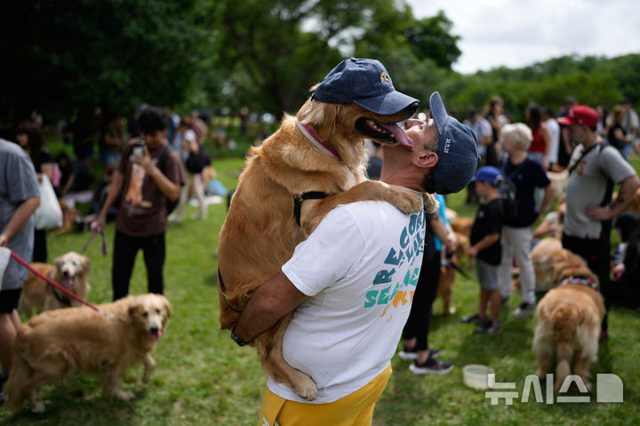 [부에노스아이레스=AP/뉴시스] 8일(현지 시간) 아르헨티나 부에노스아이레스 팔레르모 공원에서 열린 세계에서 가장 많은 골든 리트리버가 한자리에 모이는 세계 기록 도전 행사에 참가한 참가자들이 반려견과 즐거운 시간을 보내고 있다. 2025.12.09.