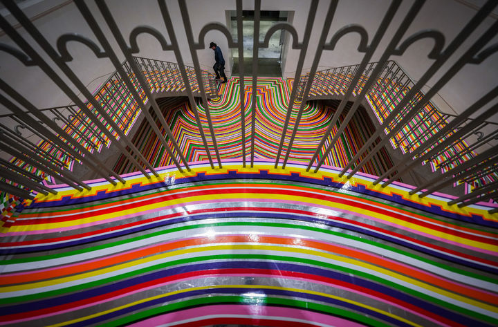 [밴쿠버=AP/뉴시스] 8일(현지 시간) 캐나다 밴쿠버의 밴쿠버 아트 갤러리에서 한 방문객이 예술가이자 음악가인 짐 램비의 전시 ‘조밥·컬러크롬'(Zobop·Colour-Chrome)이 설치된 계단을 오르고 있다. 착시 현상을 일으키는 바닥 설치 작품으로 유명한 램비의 이번 전시도 갤러리 계단과 홀 바닥에 설치됐다. 2025.12.09.